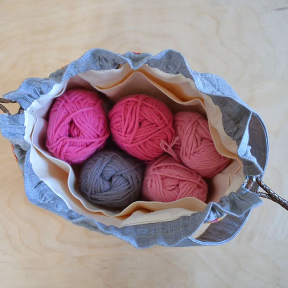 a Drawstring Bag with five balls of yarn inside