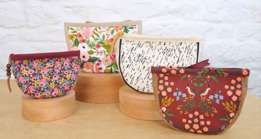 four luna pouches, with three of them on wooden stands