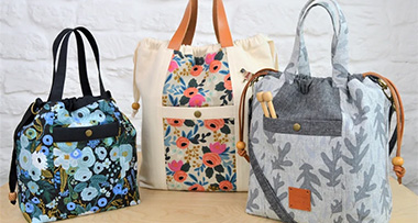 three Maxine tote bags of different sizes and patterns sitting on a table