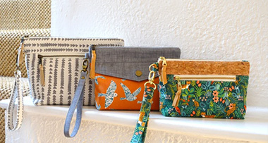 three Jackie purses sitting on a ledge next to a staircase