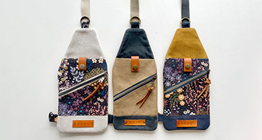 three mini traveller sling pouches on a white background