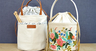 two bucket bags with different patterns sitting on a wooden surface