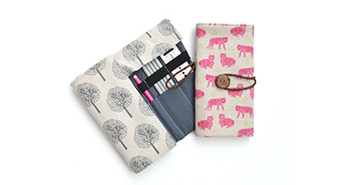 two knitting needle cases, one open and the other shut on a white background