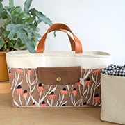 a tote bag sitting on a table with a plant next to it